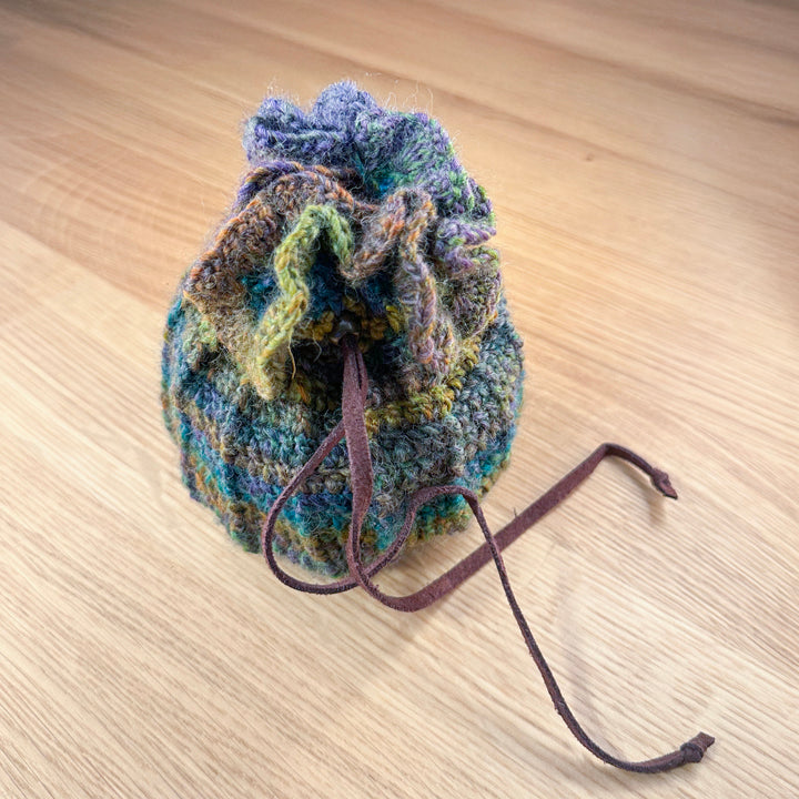 closed crochet pouch in green, blues and purples, part of the handmade hoard and Fateweaver's collection