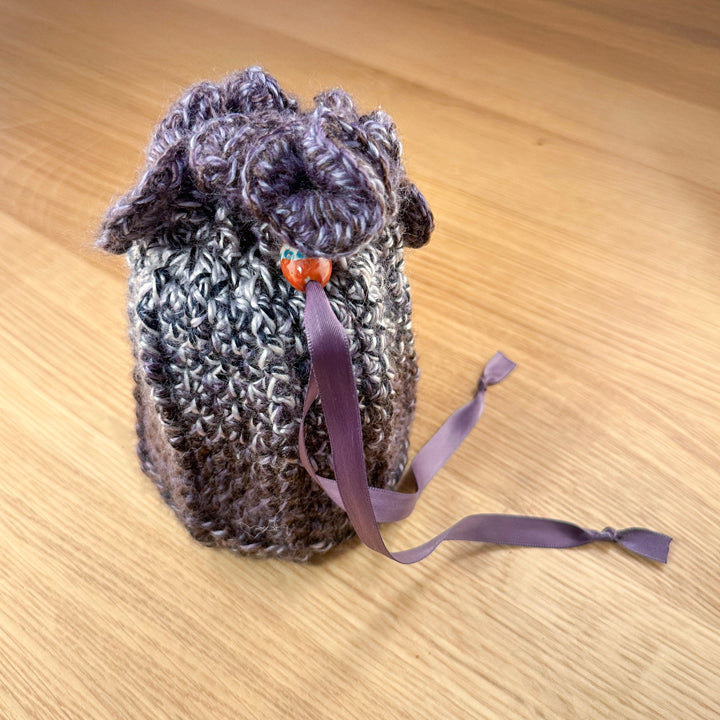 Closed crochet pouch in purple and white yarn, part of the handmade hoard and Fateweaver's collection